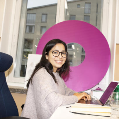 Henkilö tutustuu työllisyysavustushakemuksen kriteereihin pöytäkonellaan