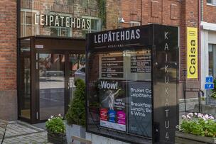Kulttuurikeskus Caisan sisäänkäynti: punatiilisessä talossa valokyltti "Leipätehdas", mainosvitriini ja keltainen banderolli, jossa lukee Caisa.