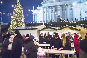 Ihmisiä torikojujen edessä Senaatintorilla. Taustalla Tuomiokirkko ja joulukuusi.