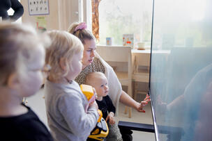 An adult and children in kindergarten.