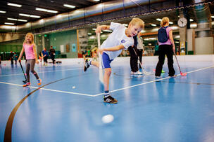 Children are playing floorball.