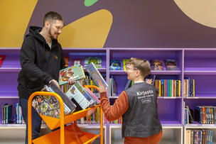 Two library employees at the bookshelf of the Kalasatama library.