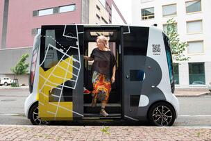 Matkustaja nousemassa ulos robottibussista. 