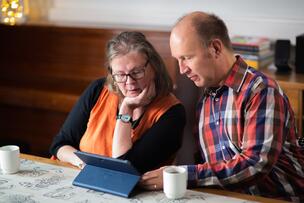 Two people using a tablet.
