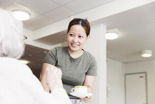 Jenelyn is serving coffee for a customer.