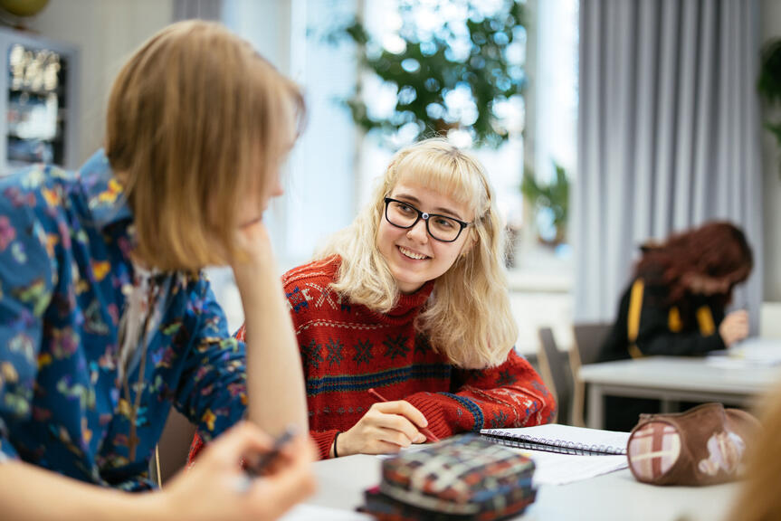 Kaksi koululaista pulpetin äärellä