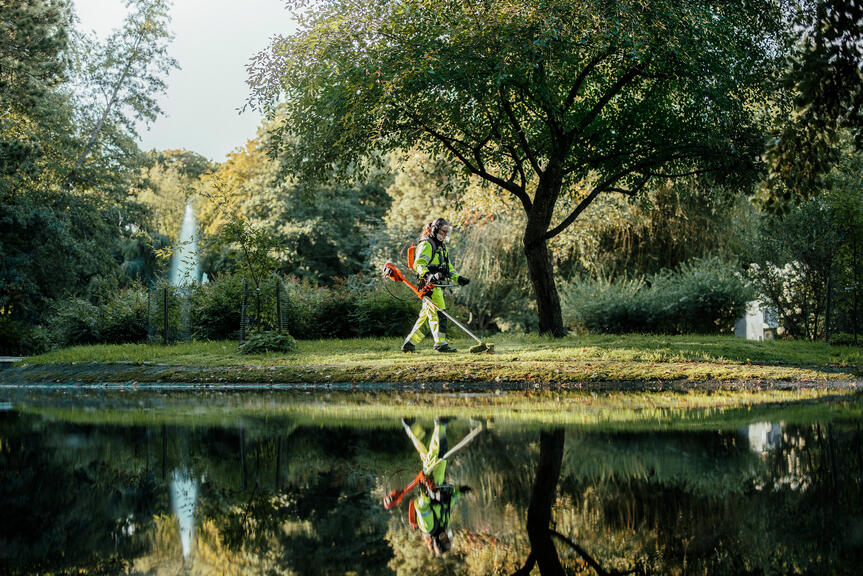 A worker mows the lawn.