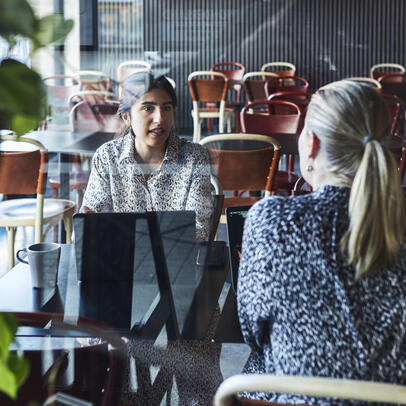 .امرأتان تتحدثان حول الحاسوب