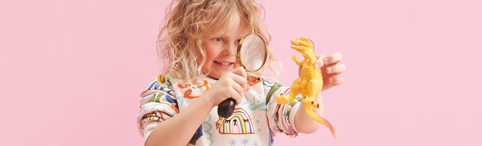 Lapsi vaaleanpunaisen taustan edessä