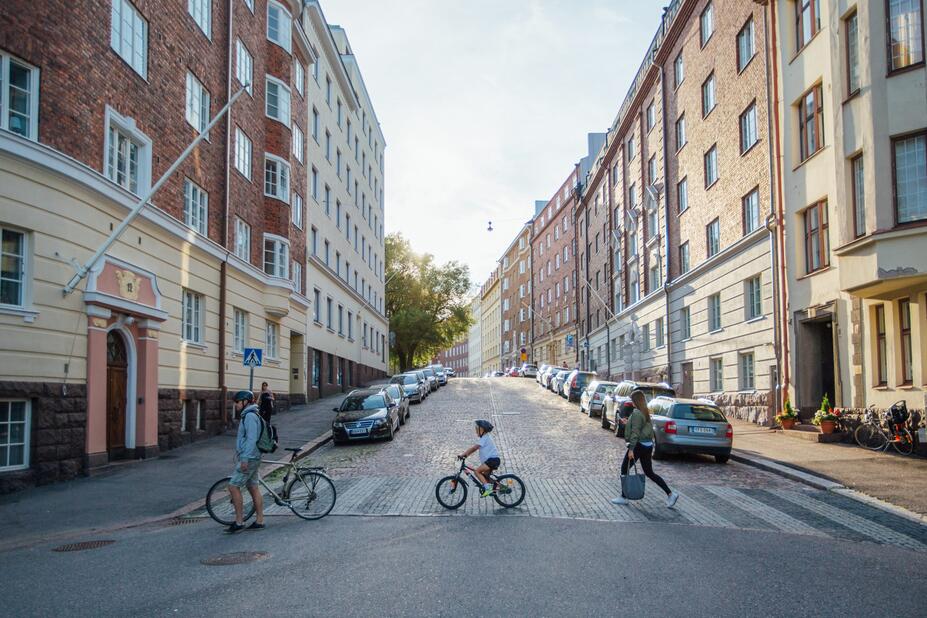 Adult and child cyclists crossing the street in Töölö.