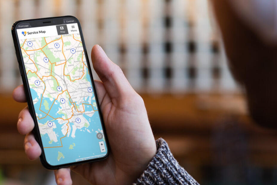 A person checking Helsinki's service map on their phone.