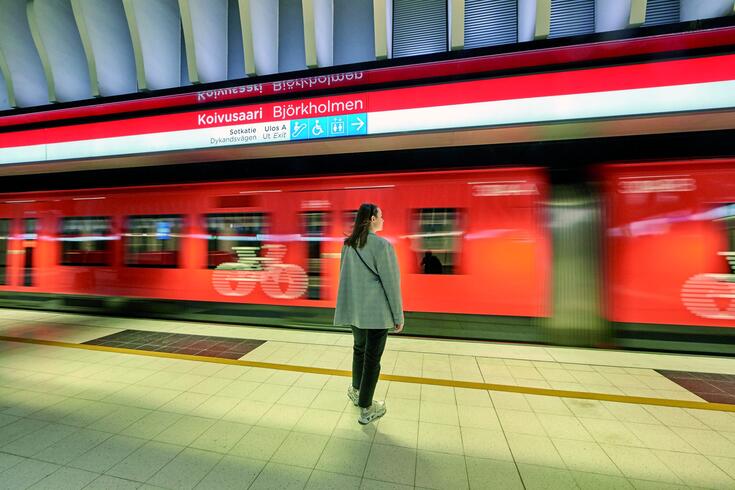 Woman waiting for incoming train in Koivusaari metro station.