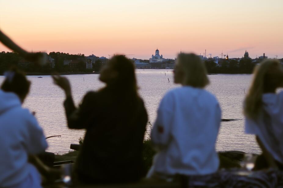 Girls sitting by the sea, Helsinki Cathedral on the background.