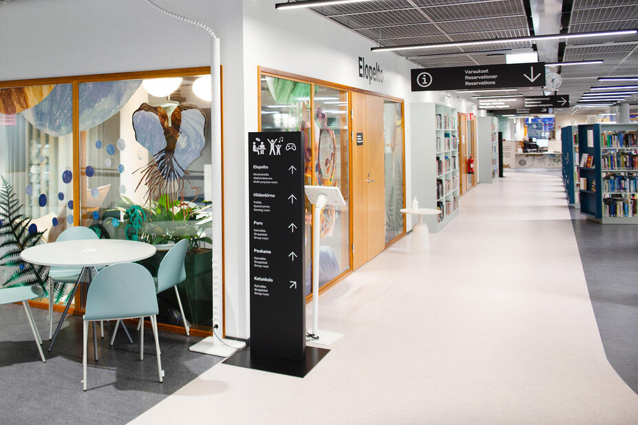 Black floors and wall signs in the lobby of Viikki library.
